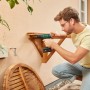 Mann montiert Holzregal mit Bosch Akkubohrschrauber EasyDrill 18V-40 an Hauswand. Grüner Akkuschrauber im Einsatz.
