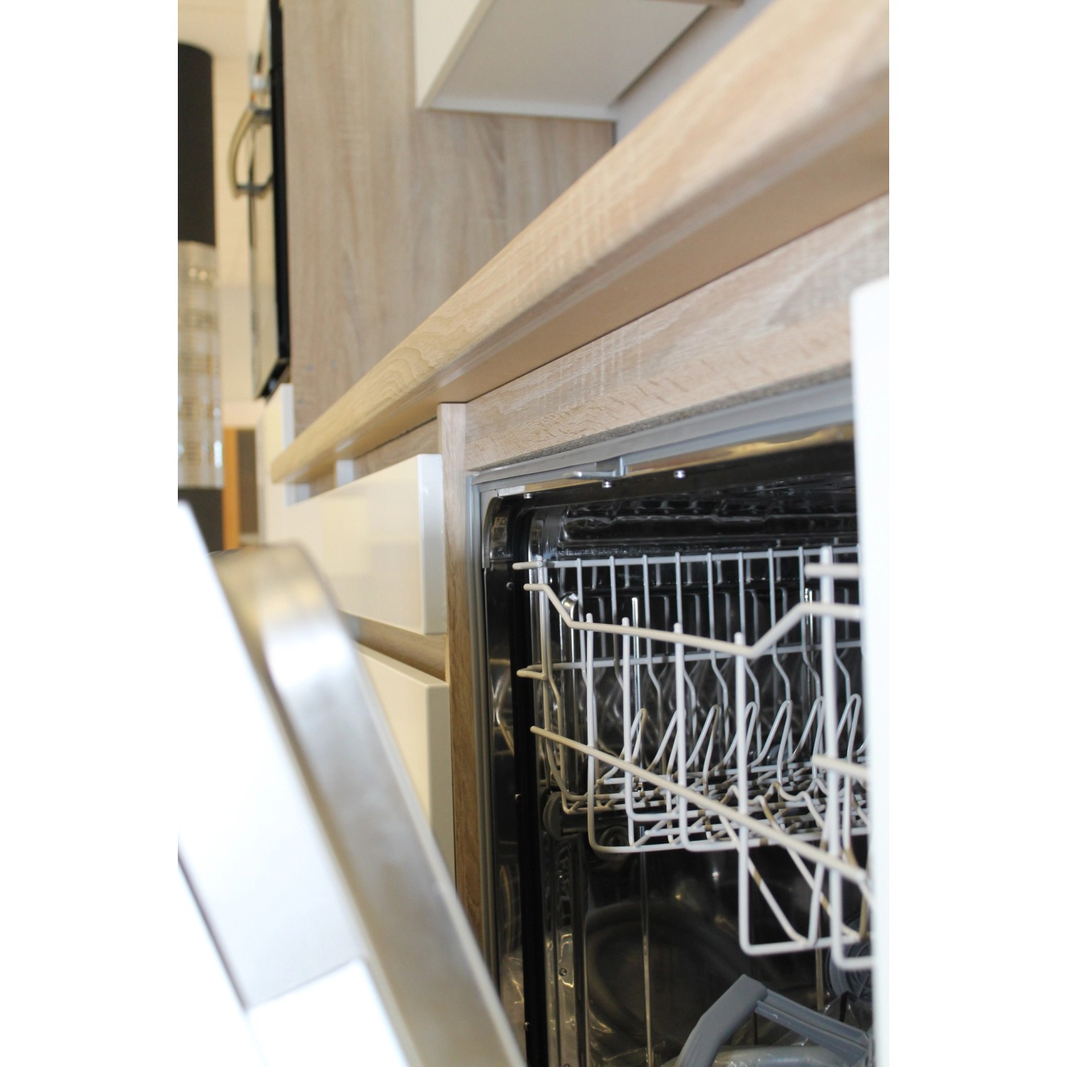 Detailaufnahme: Respekta Küchenzeile mit offenem Geschirrspüler. Grifflos, schwarz-weiß.