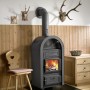 Schwarzer Wamsler Etna Kaminofen aus Gusseisen (9 kW) mit brennendem Holz im Feuerraum.