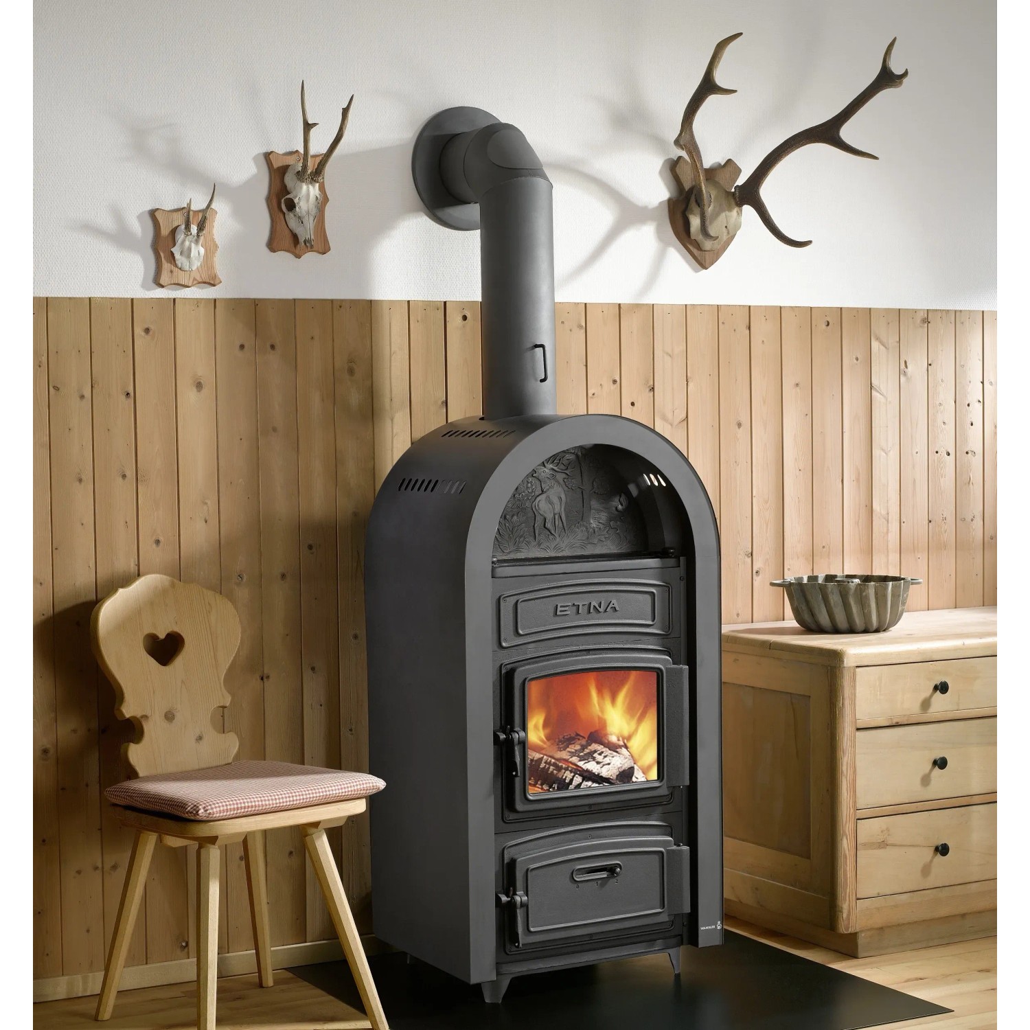 Schwarzer Wamsler Etna Kaminofen aus Gusseisen (9 kW) mit brennendem Holz im Feuerraum.