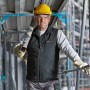 Bosch Professional Akku-Heizweste GHV 12+18V XA in Schwarz, getragen von Bauarbeiter mit Helm.