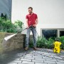 Mann reinigt Mauer mit gelbem Kärcher Hochdruckreiniger K 2 Power Control.
