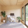 Innenansicht: Hellgraues Palmako Holz-Gartenhaus mit Pultdach als Büro mit Schreibtisch und Fenster.