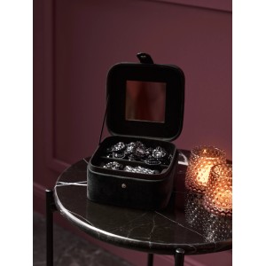 Geöffnete, schwarze Schmuckbox Midnight Mystery mit Spiegel und Schmuck auf einem Tisch.