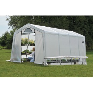 Weißes ShelterLogic Gewächshaus (18,3 m²) mit Frau beim Pflanzen. Ideal für Tomatenzucht.