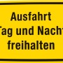 Gelbes Hinweisschild: Ausfahrt Tag und Nacht freihalten.