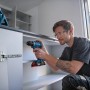 Handwerker mit Bosch Professional Akku-Bohrschrauber GSR 18V-45 beim Schrauben an einem Schrank.