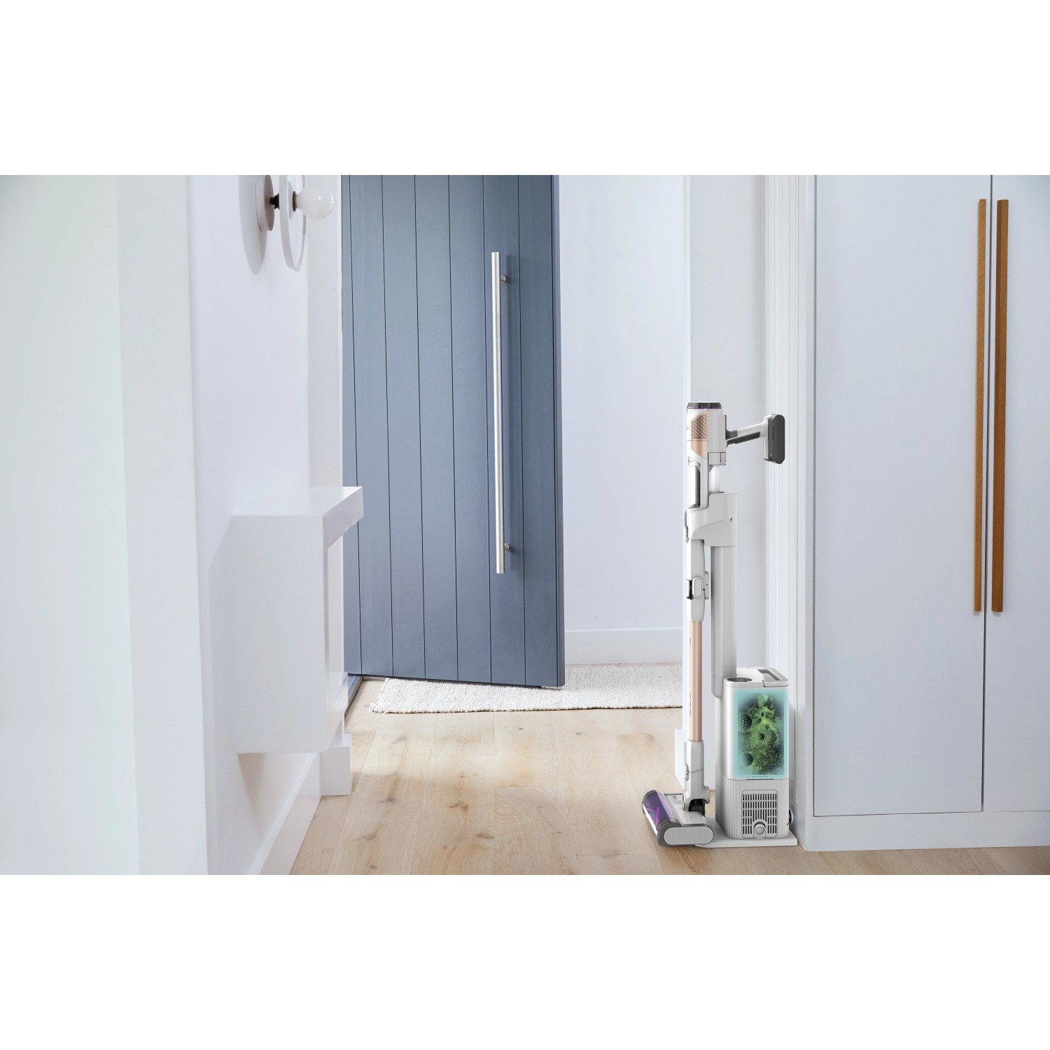 Shark Akkusauger Detect Pro mit Absaugstation im Flur. Der Bodenstaubsauger ist weiß und lila.