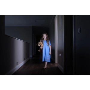 Mädchen mit Teddy im dunklen Flur, beleuchtet durch Osram LED-Nachtlicht Nightlux.
