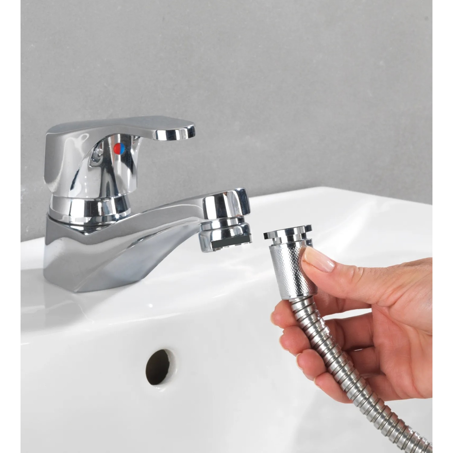 Wenko Waschbeckenbrause mit Edelstahl-Duschschlauch wird an einem Waschbecken montiert.