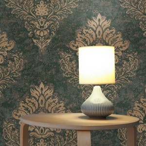 Tadessi Vliestapete in Grün mit goldenem Barock-Ornamentmuster. Dekorative Wandgestaltung für luxuriöses Ambiente.