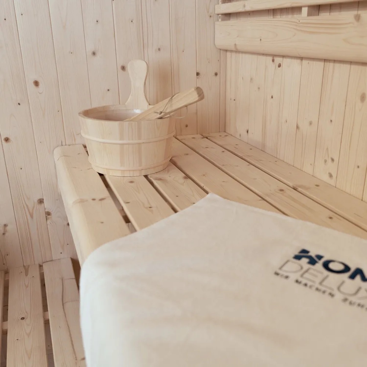 Detailaufnahme: Home Deluxe Sauna SHADOW BIG XL mit Zubehör (Kelch, Kelle) und Handtuch auf der Saunabank.