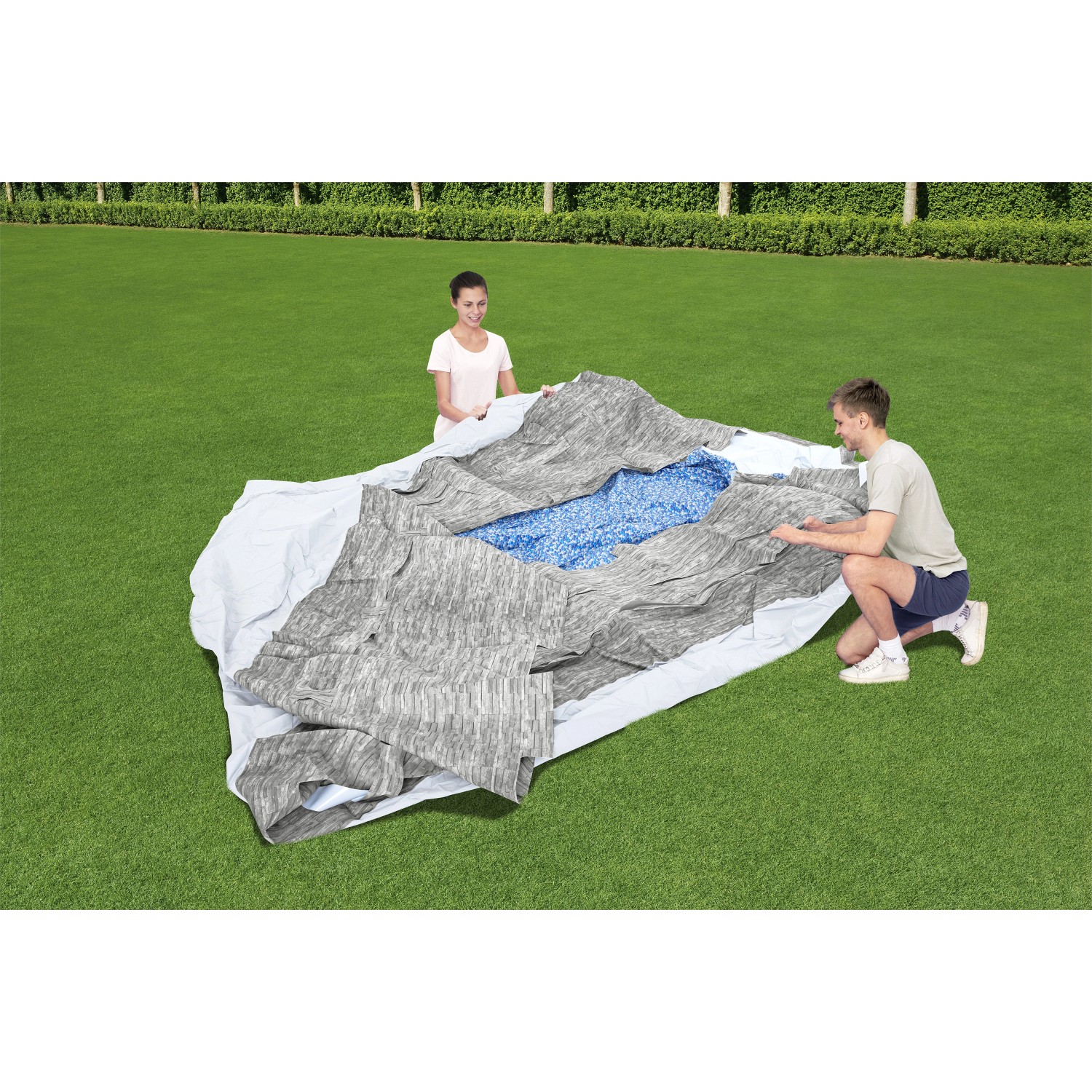 Bestway Stahlrahmenpool Swim Vista im Garten beim Aufbau mit zwei Personen.