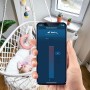 Hand steuert Bosch Smart Home Heizkörper-Thermostat II per App, Baby im Hintergrund.