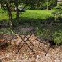 Balkon-Set Mangan von Garden Pleasure, schwarz-braun, mit Tisch und zwei Stühlen im Garten.