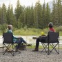 Zwei Personen sitzen auf grauen Sunula Campingstühlen mit Getränkehalter am See.