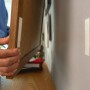 Anwendung der Tesa Powerstrips Click Small: Bilderrahmen wird an der Wand befestigt.