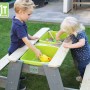 EXIT Aksent Sand-, Wasser- und Picknicktisch mit 2 Bänken im Garten mit spielenden Kindern.