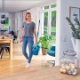 Frau mit Leifheit Clean Twist Disc Mop Ergo Reinigungsset und Eimer zur Bodenreinigung.