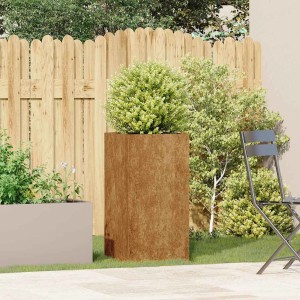 Hoher, rechteckiger Pflanzkübel aus rostigem wetterfestem Stahl mit grüner Pflanze auf Terrasse.