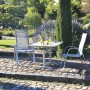 Rechteckiger Acamp Klapptisch Platin-Cemento (120x80 cm) mit zwei Stühlen im Garten.