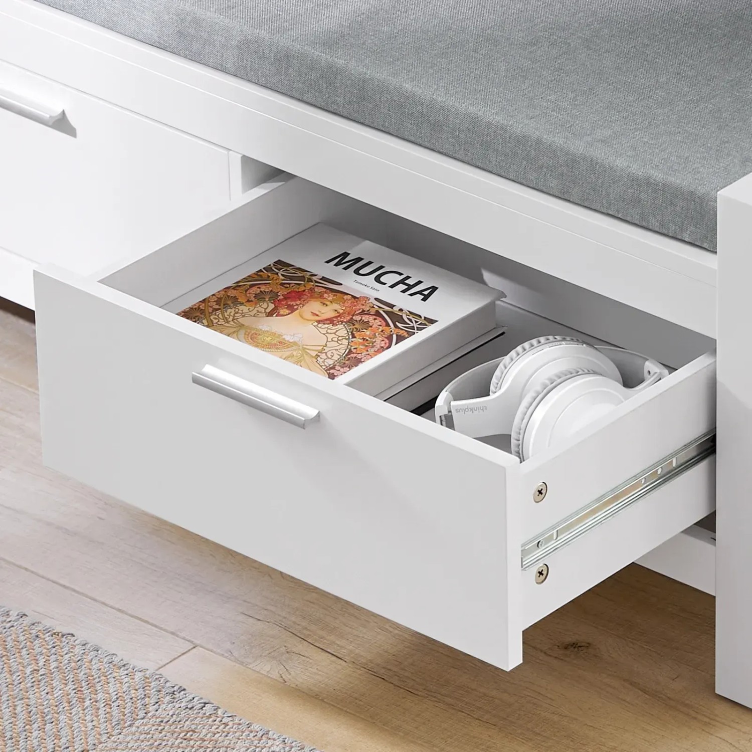 Weiße Schuhbank SoBuy FSR74-W mit Schublade offen, gefüllt mit Buch und Kopfhörern.
