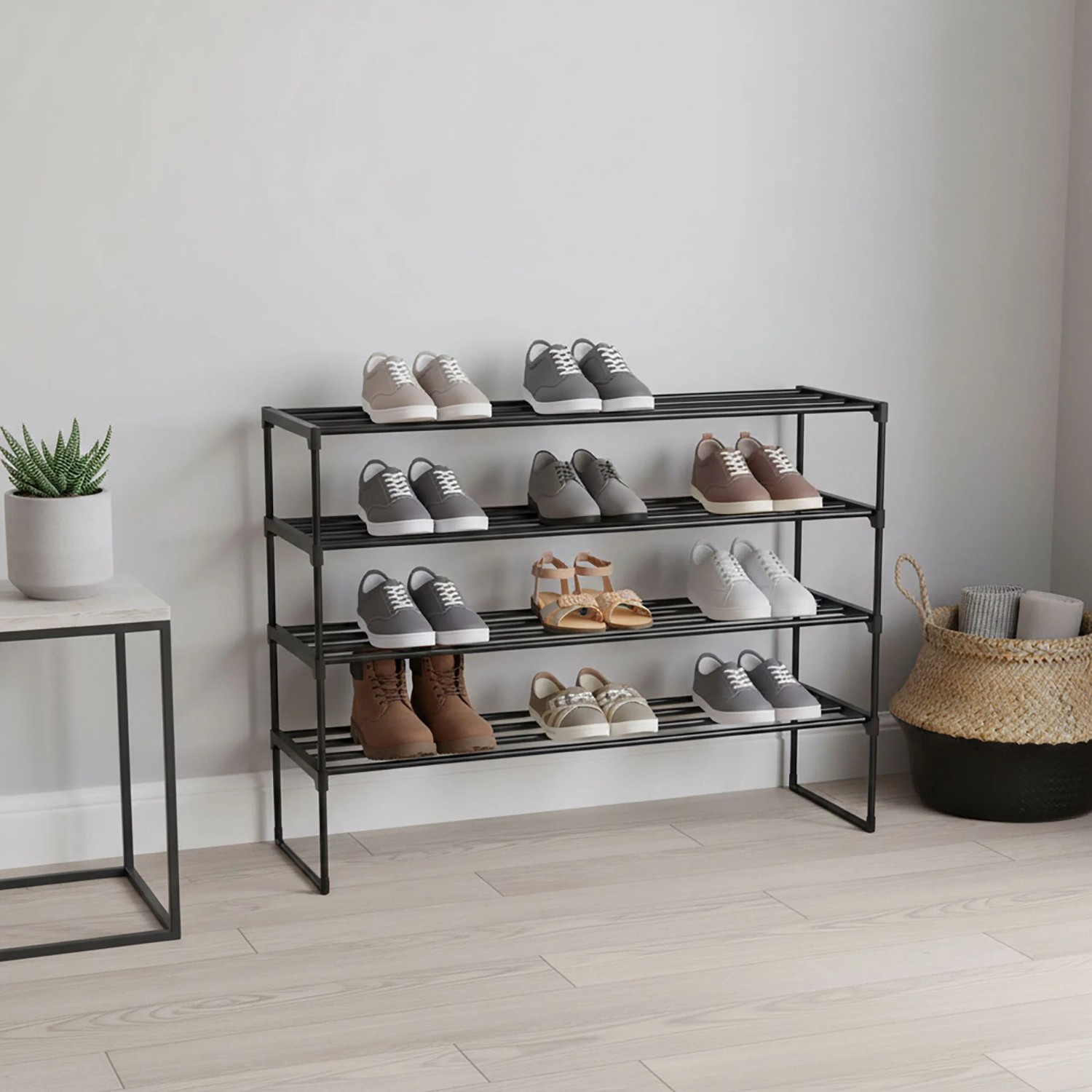 Schwarzes Metall Schuhregal mit 4 stapelbaren Ebenen, gefüllt mit Schuhen im Flur. Praktisches Stecksystem für Ordnung.