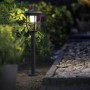 Philips Solar-Wegeleuchte Spiess Radii: Schwarze Sockelleuchte mit Solarpanel und warmweißem Licht im Garten.