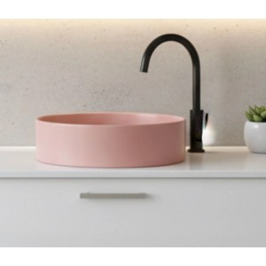 Rundes rosa Keramik Aufsatzwaschbecken, 42 cm, auf Waschtisch mit schwarzem Wasserhahn. Für modernes Bad.
