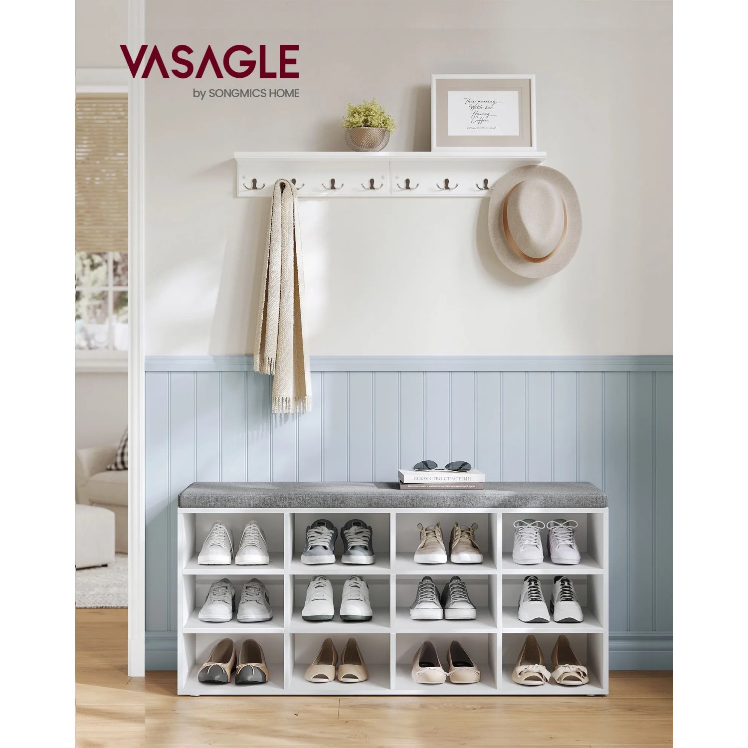 Vasagle Schuhbank in Weiß-Grau mit 12 Fächern und gepolsterter Sitzfläche vor hellblauer Wand.
