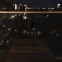 Schwarze, dimmbare LED Tischlampe für den Außenbereich mit CCT-Funktion auf einem Holztisch.