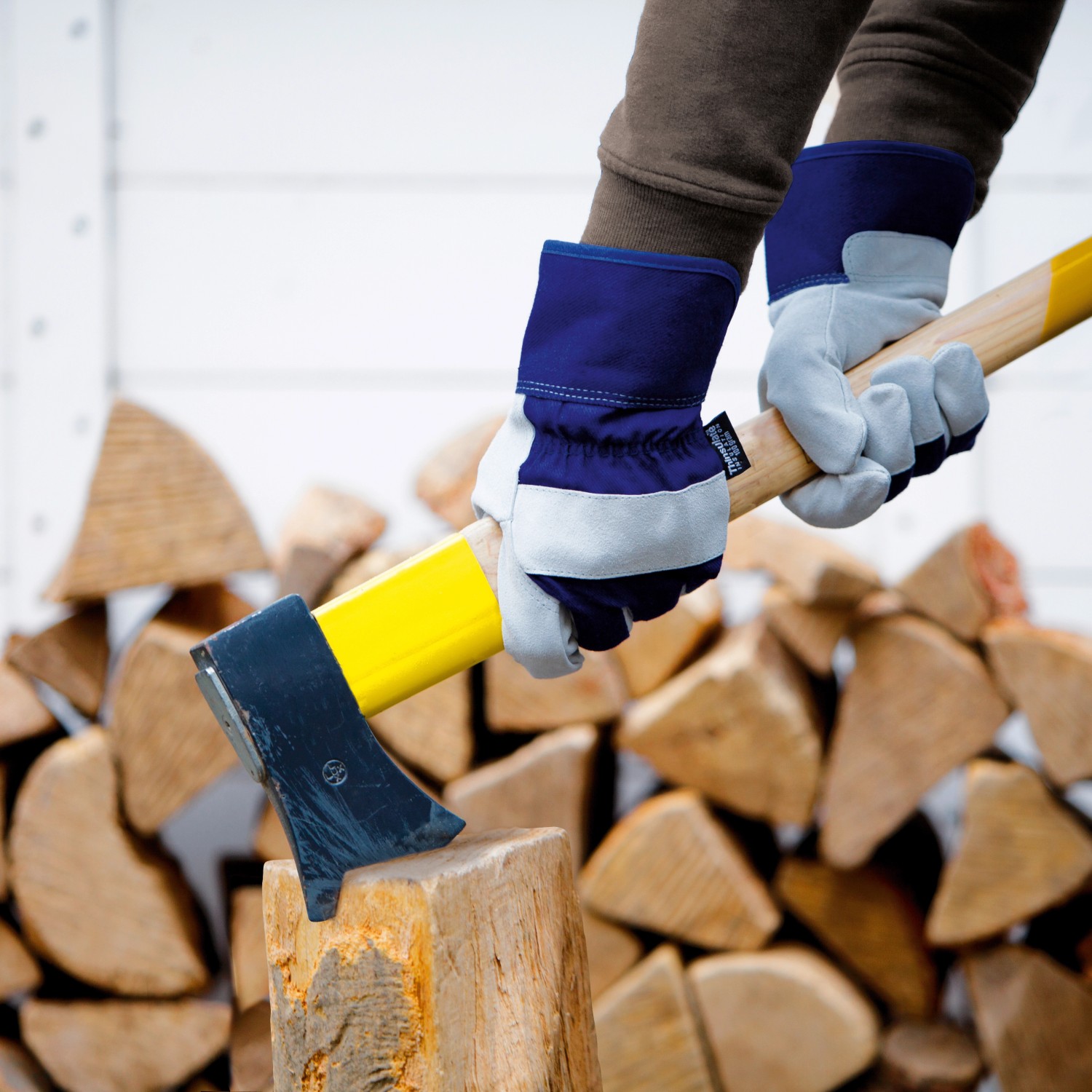 Rindspaltleder Arbeitshandschuhe (Größe 10) beim Holzhacken. Gartenbekleidung für sicheres Arbeiten.