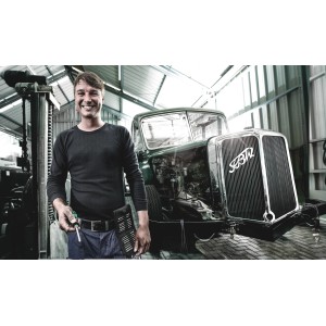 Mann mit Wera Bit-Schraubendreher Set Kraftform Kompakt 60 vor Oldtimer-LKW in Werkstatt.