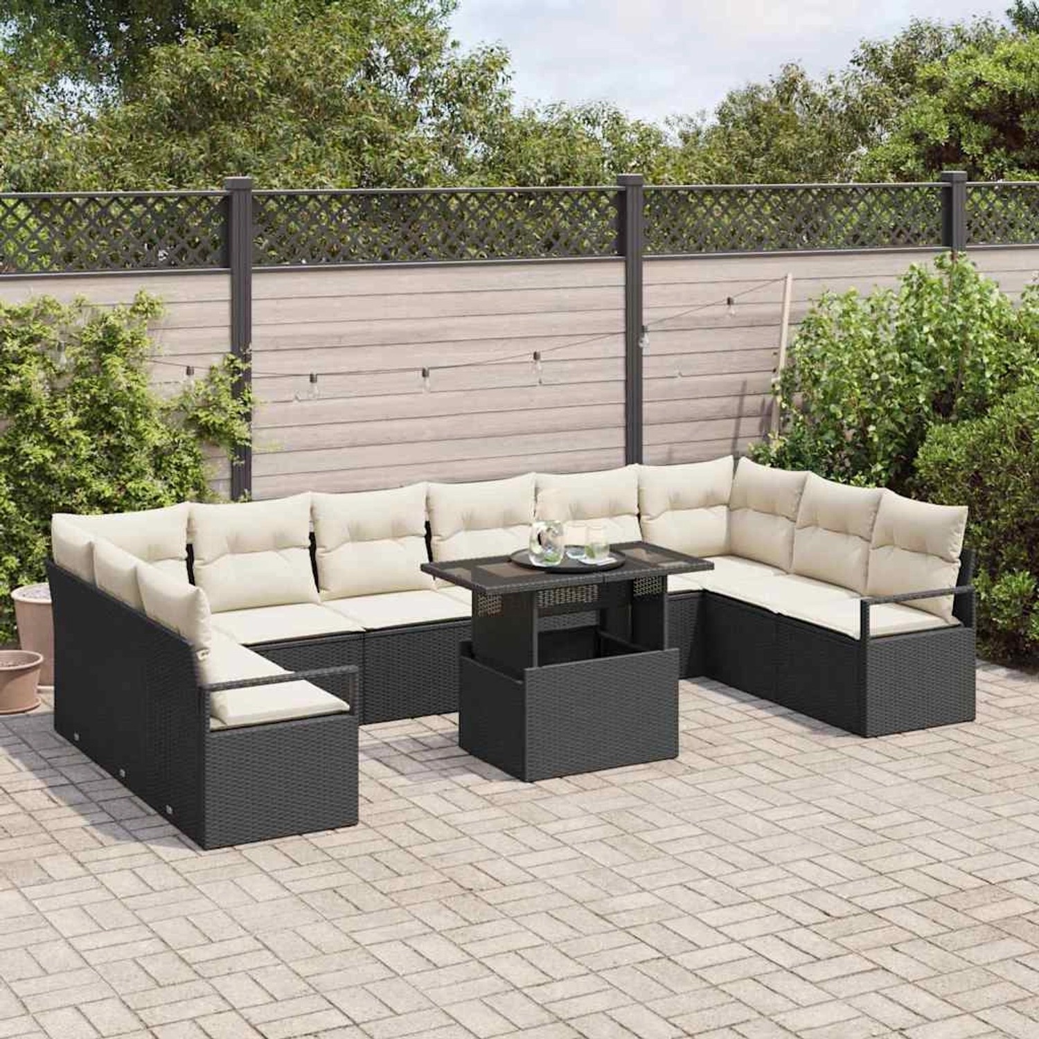 Schwarzes 11-teiliges Garten-Sofa-Set aus Poly Rattan mit Tisch und cremefarbenen Kissen.