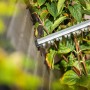 LUX Akku-Heckenschere ZHT737-1V im Einsatz beim Heckenschnitt. Silberne Messer schneiden grüne Blätter.
