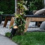 Schwarzer QAZQA Gartenstrahler Done mit Kabel und Stecker (IP65) im Garten mit Bepflanzung.