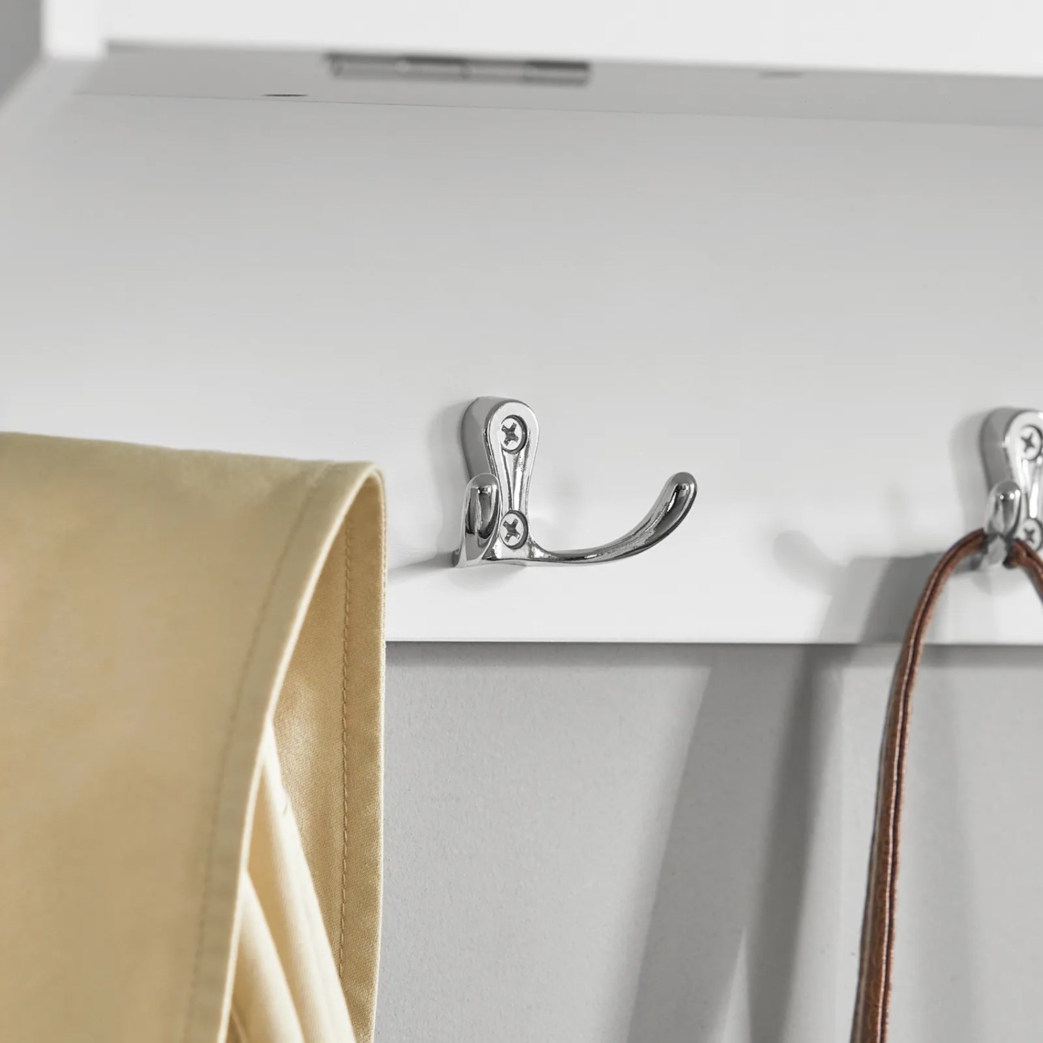Detailaufnahme: Weiße SoBuy Wandgarderobe mit Chromhaken und teilweise sichtbarer Jacke.