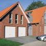 Hörmann Berry Schwingtor N80, Motiv 902 Weiß, eingebaut in eine Doppelgarage aus Backstein.