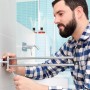 Mann montiert Tesa Handtuchhalter Smooz, zweiarmig, verchromt im Badezimmer.