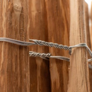 Detailaufnahme: Stiltreu Mini Steckzaun aus Holz mit Draht verbunden.