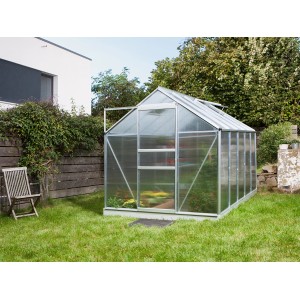 Vitavia Gewächshaus Venus 6200 aus Alu blank im Garten. Das Gewächshaus ist rechteckig und hat eine Tür.