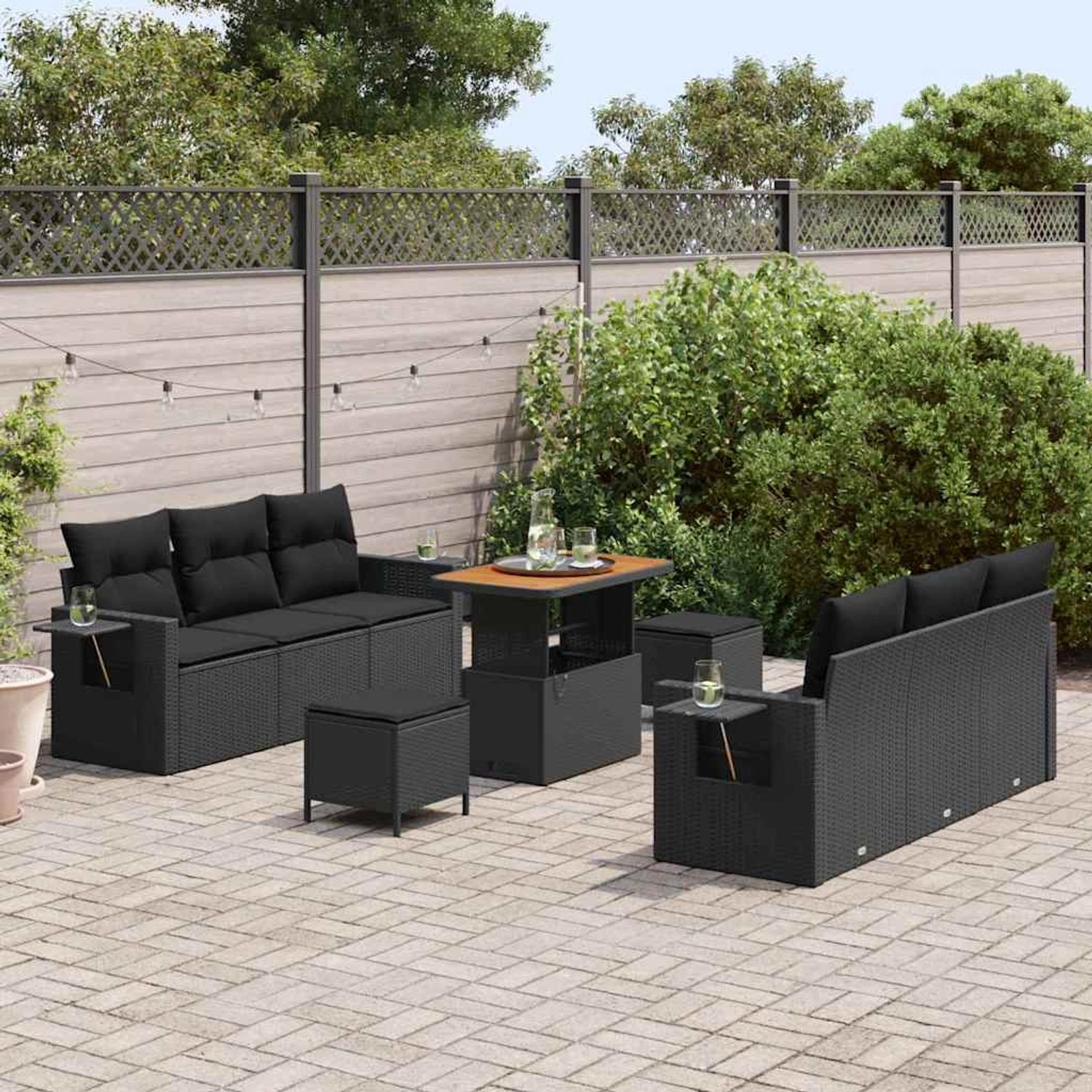 Schwarzes 9-teiliges Garten-Sofa-Set aus Poly Rattan mit Tisch und Hockern.