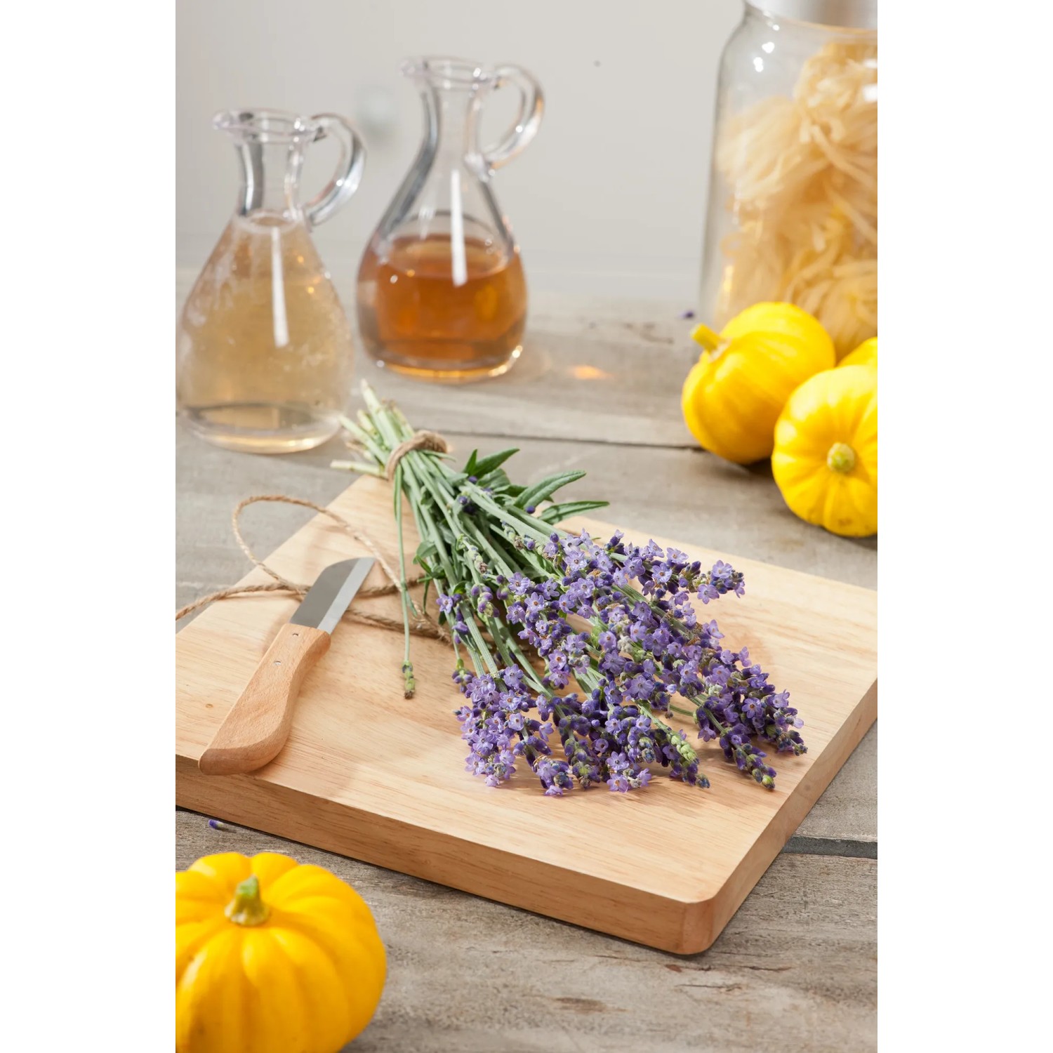 Lavendel 'Hidcote' von GROW by OBI als Bund auf Holzbrett mit Messer und Dekoration.