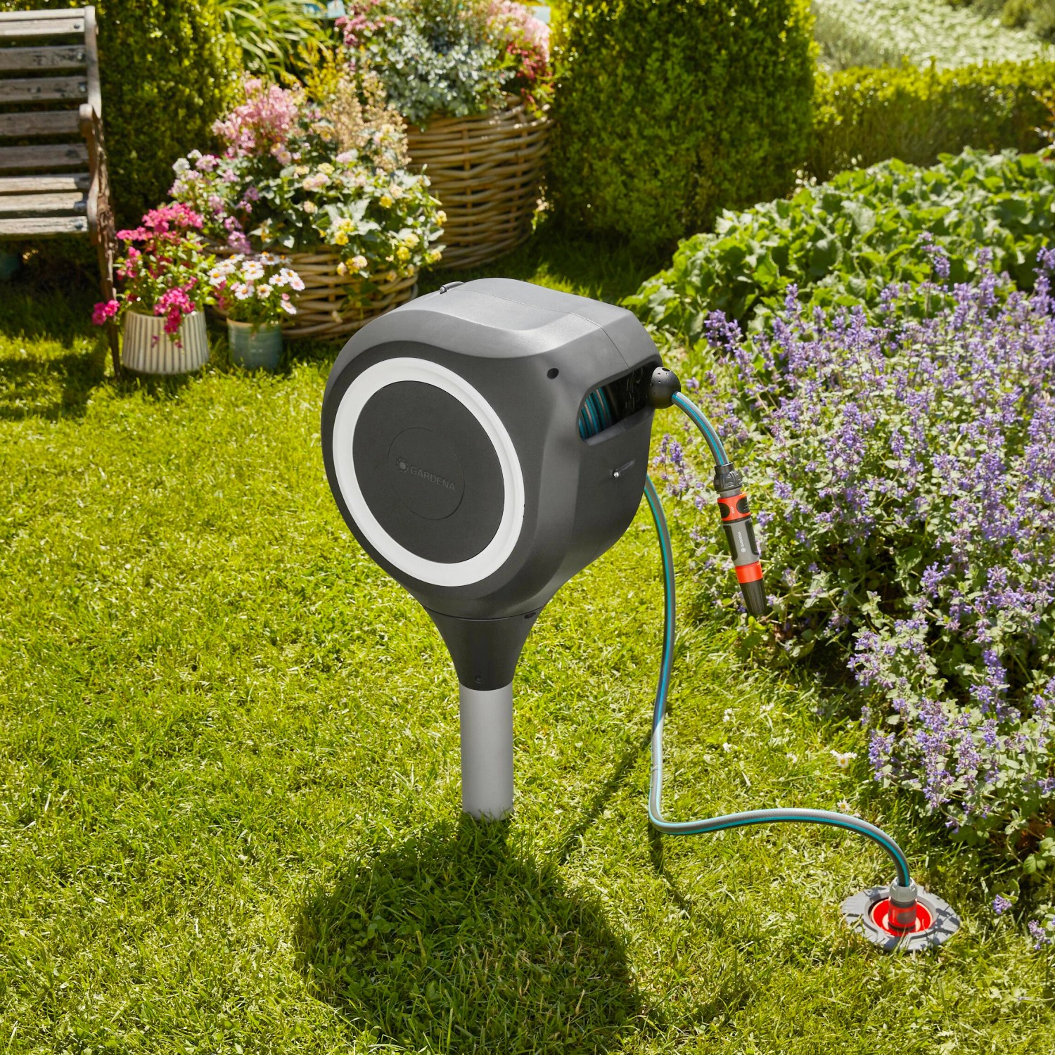 Gardena RollUp S 15 m Gartenschlauchbox mit Schlauch und Erdspieß im Garten.