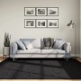 Schwarzer Kurzflorteppich OVIEDO, 200x200 cm, vor Sofa im Wohnzimmer.