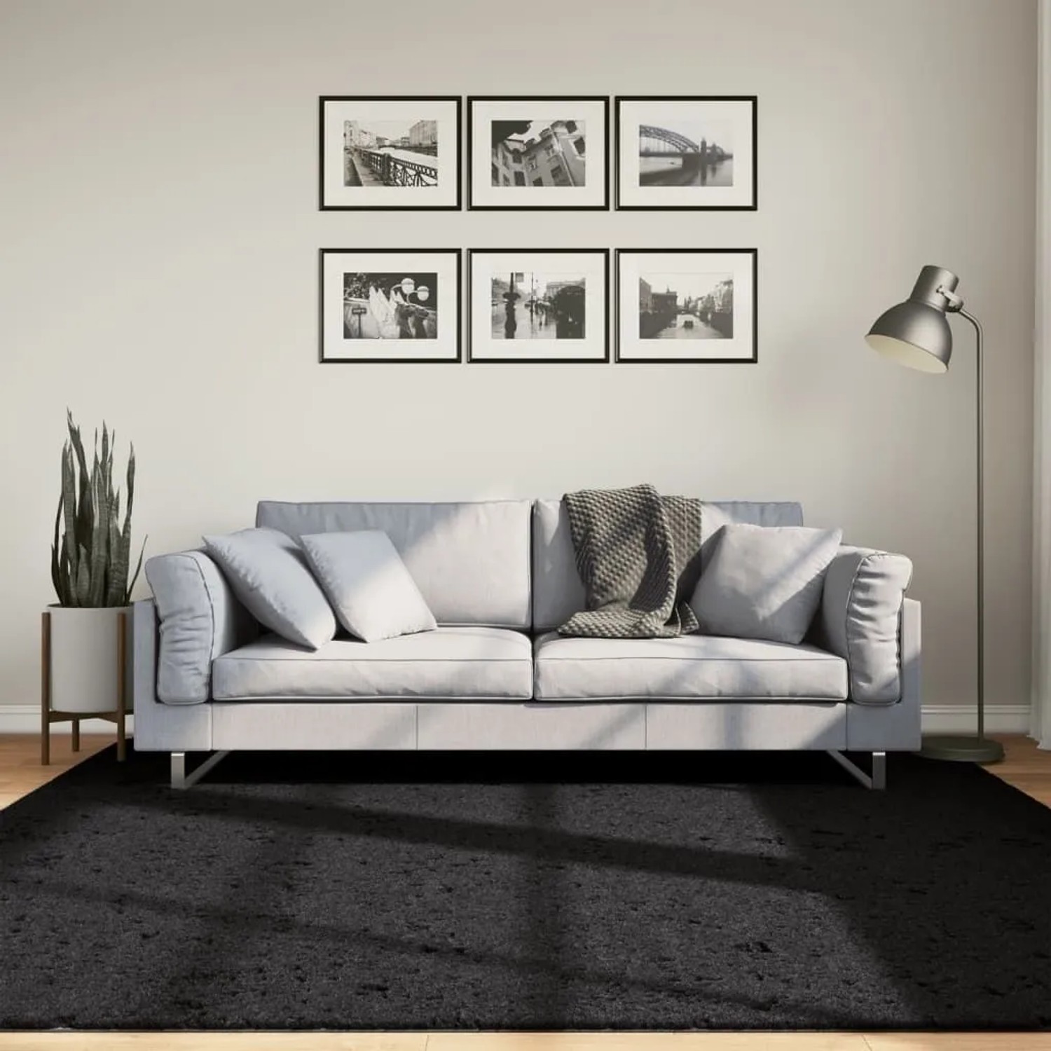 Schwarzer Kurzflorteppich OVIEDO, 200x200 cm, vor Sofa im Wohnzimmer.