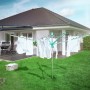 Leifheit Wäscheschirm Linomatic 500 Easy im Garten mit aufgehängter Wäsche.