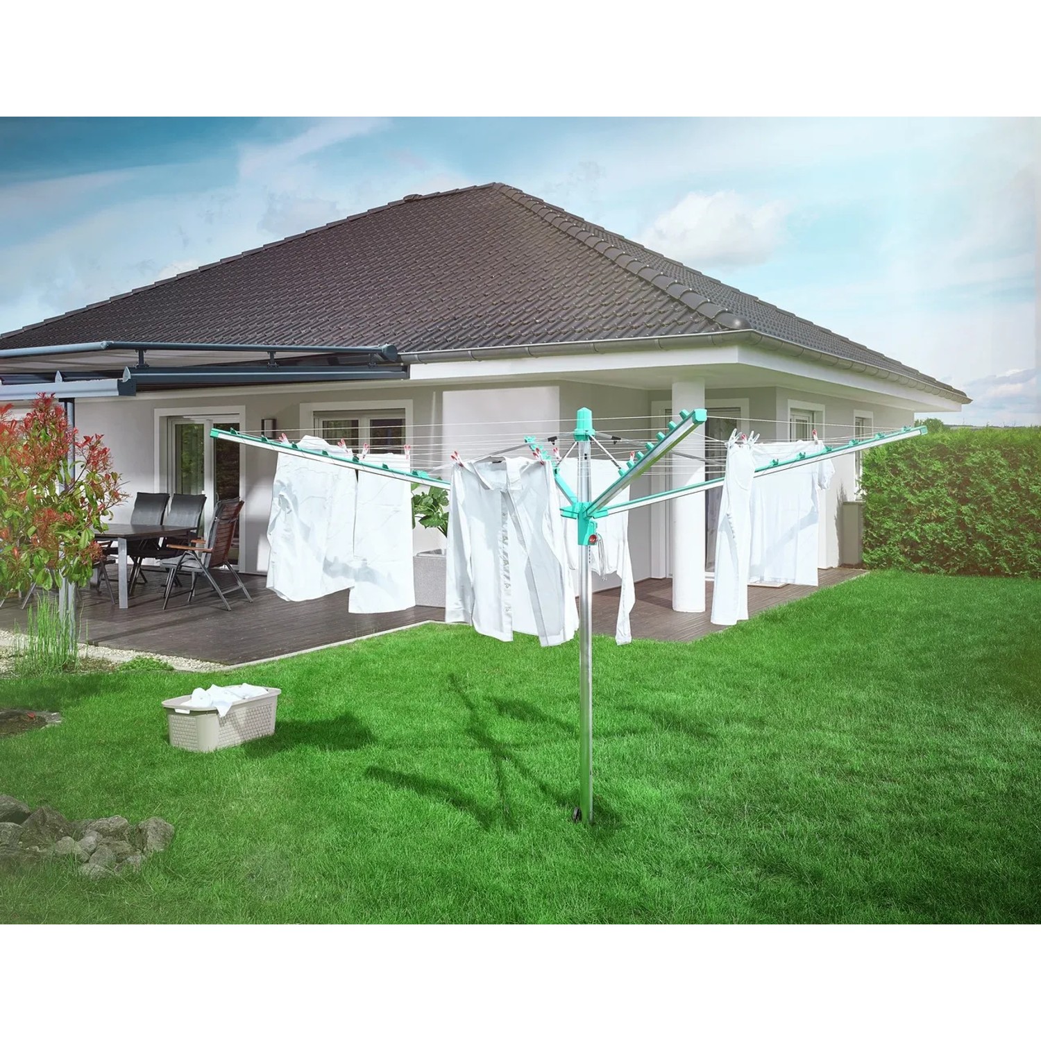 Leifheit Wäscheschirm Linomatic 500 Easy im Garten mit aufgehängter Wäsche.