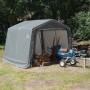 Graues Shelter Logic Metall-Gerätehaus 9 m² mit Holzlager und Holzspalter im Garten.