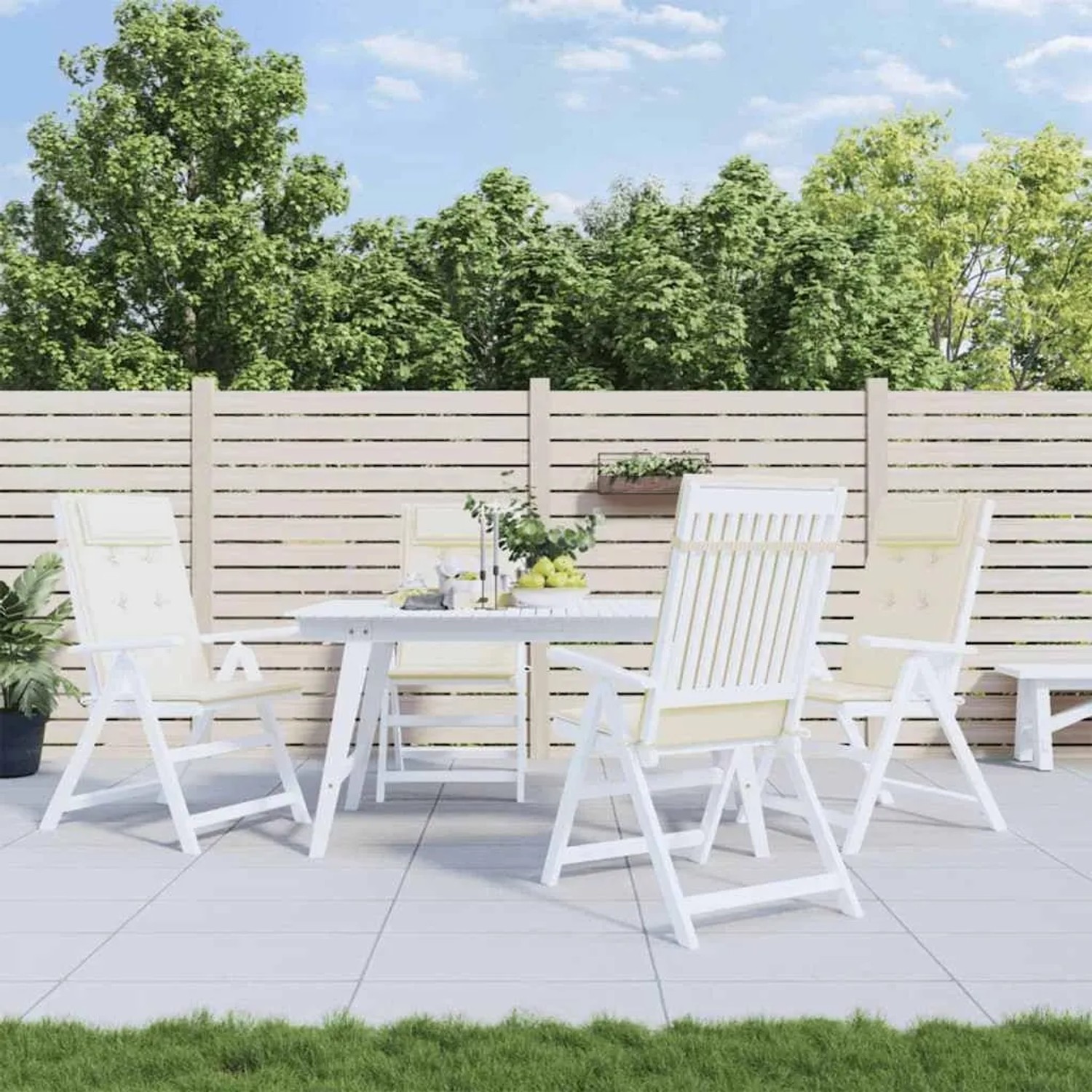 Vier cremefarbene Hochlehner-Auflagen aus Oxford-Gewebe auf weißen Gartenstühlen an einem Tisch auf der Terrasse.